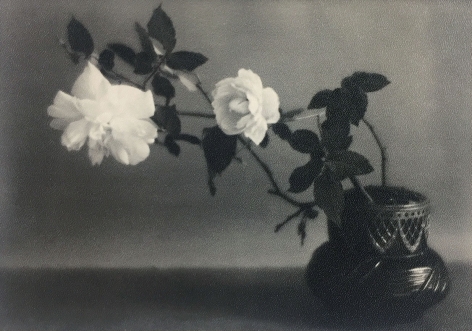 Black and white image of a decorative bowl with two white roses, circa 1920
