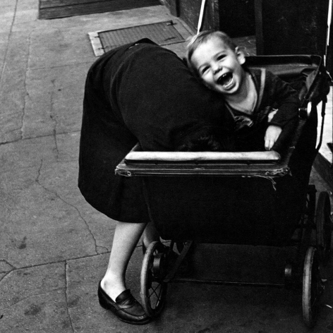 Helen Levitt, New York 1945, child in baby carriage laughs as woman sticks her head inside carriage.