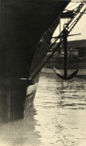 Black and white image of ship's anchor—the ship sits at the dok, circa 1920.
