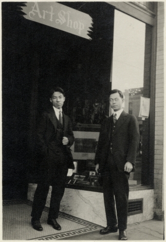 black and white photo of two Japanese American men in suits in front of their storefront—a sign reads "Art Shop"
