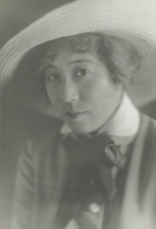 Black and white portrait of Jaapnse American silent film actress Tsuru Aoki, she is wearing a straw hat and looks at the camera, circa 1920