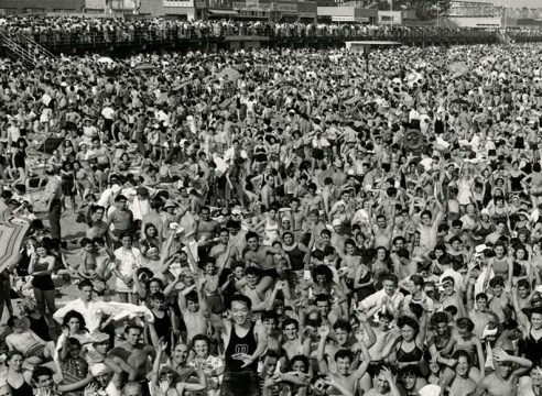 Black and white image of acrowd at Coney Island—all facing the camera—in 1946. 